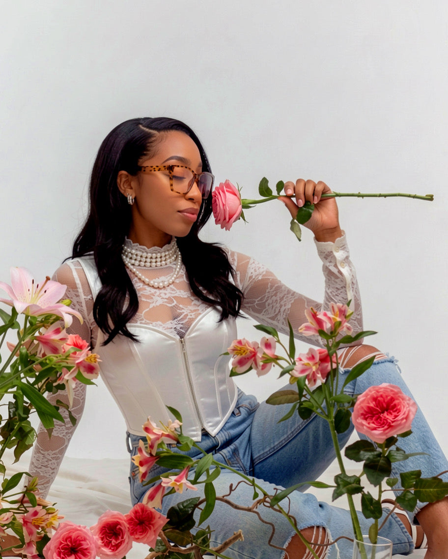 Owner of The Pink Room, Symone Grady, smelling a pink rose. 
