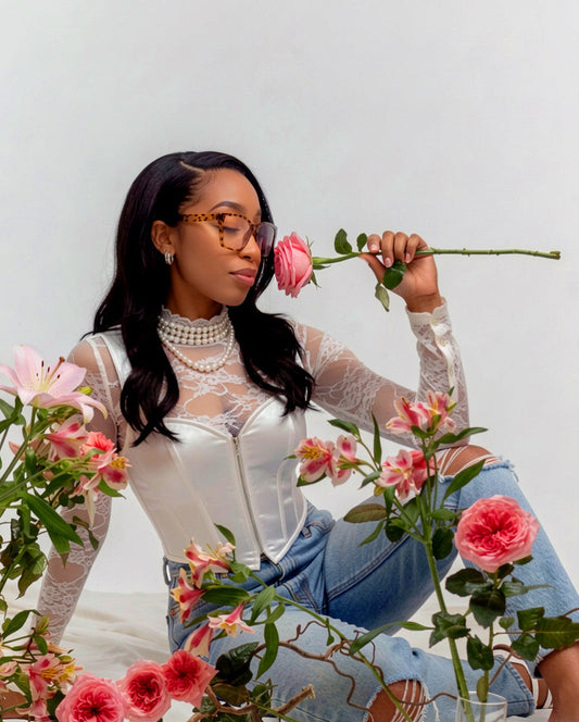 Owner of The Pink Room, Symone Grady, smelling a pink rose. 
