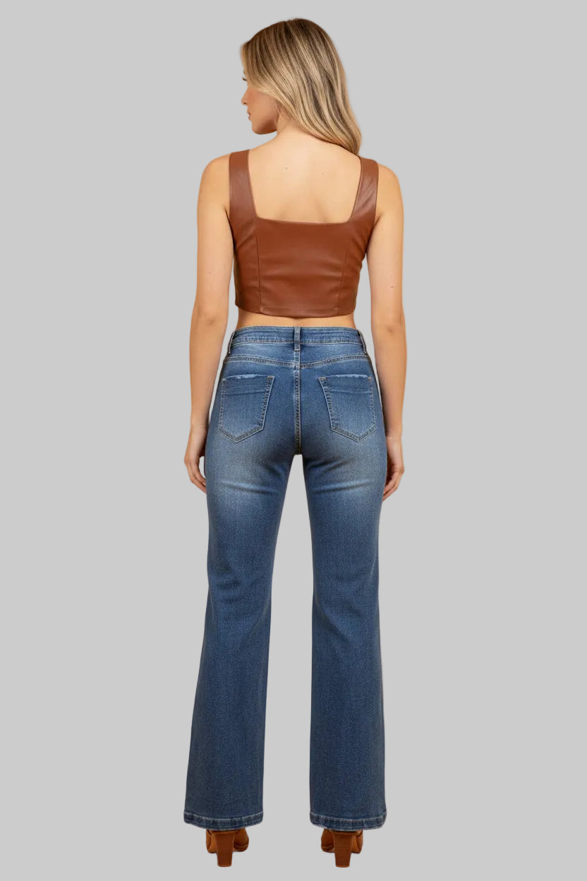 Woman wearing blue jeans and a brown top against a beige background